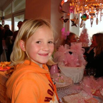 Kind lachend op kraamfeest roze